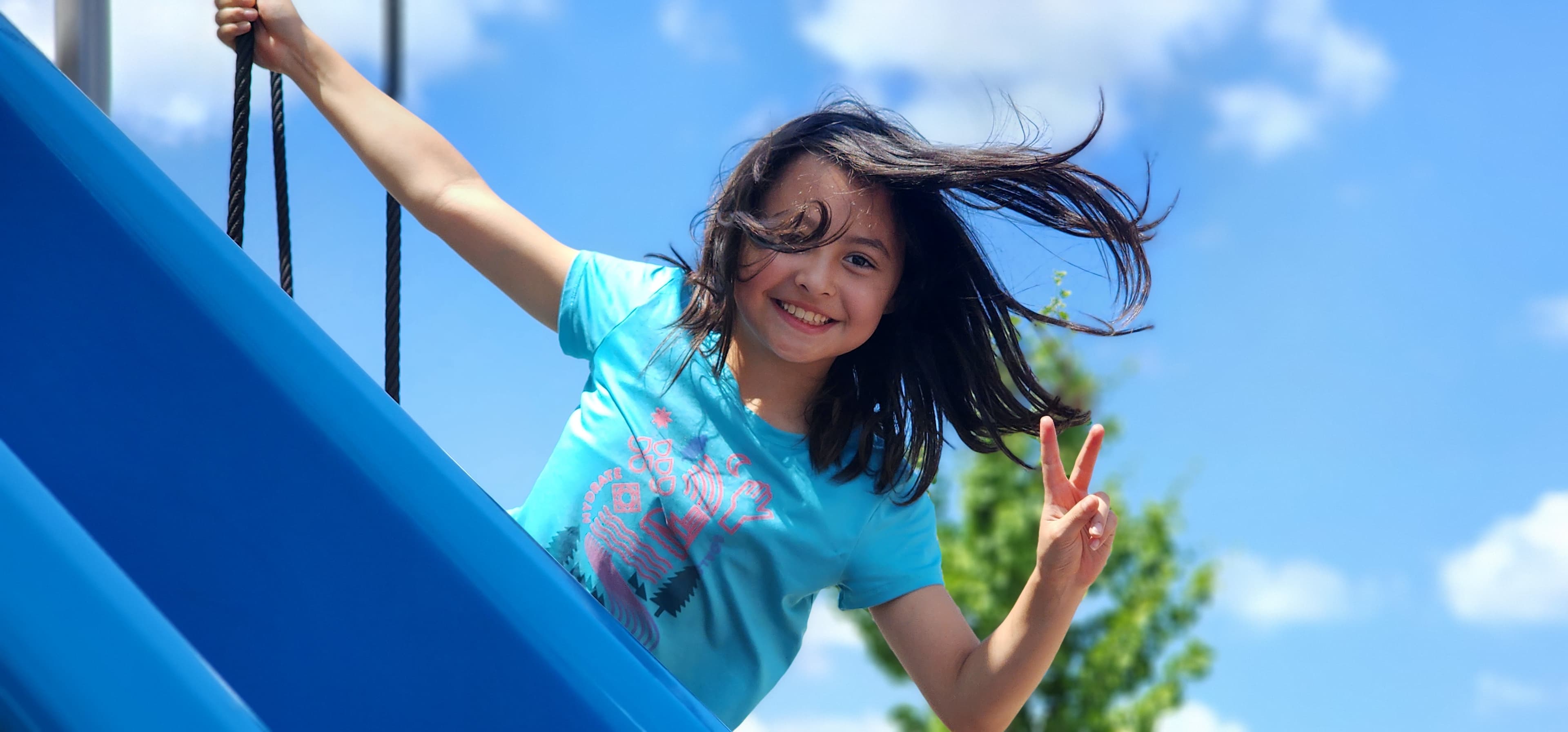 Camper smiling on a playground slide